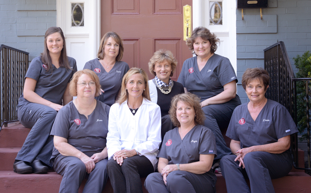 Rebecca Dunn DMD team standing together in dental office, professional white coats, warm welcoming smiles, Edwardsville Illinois